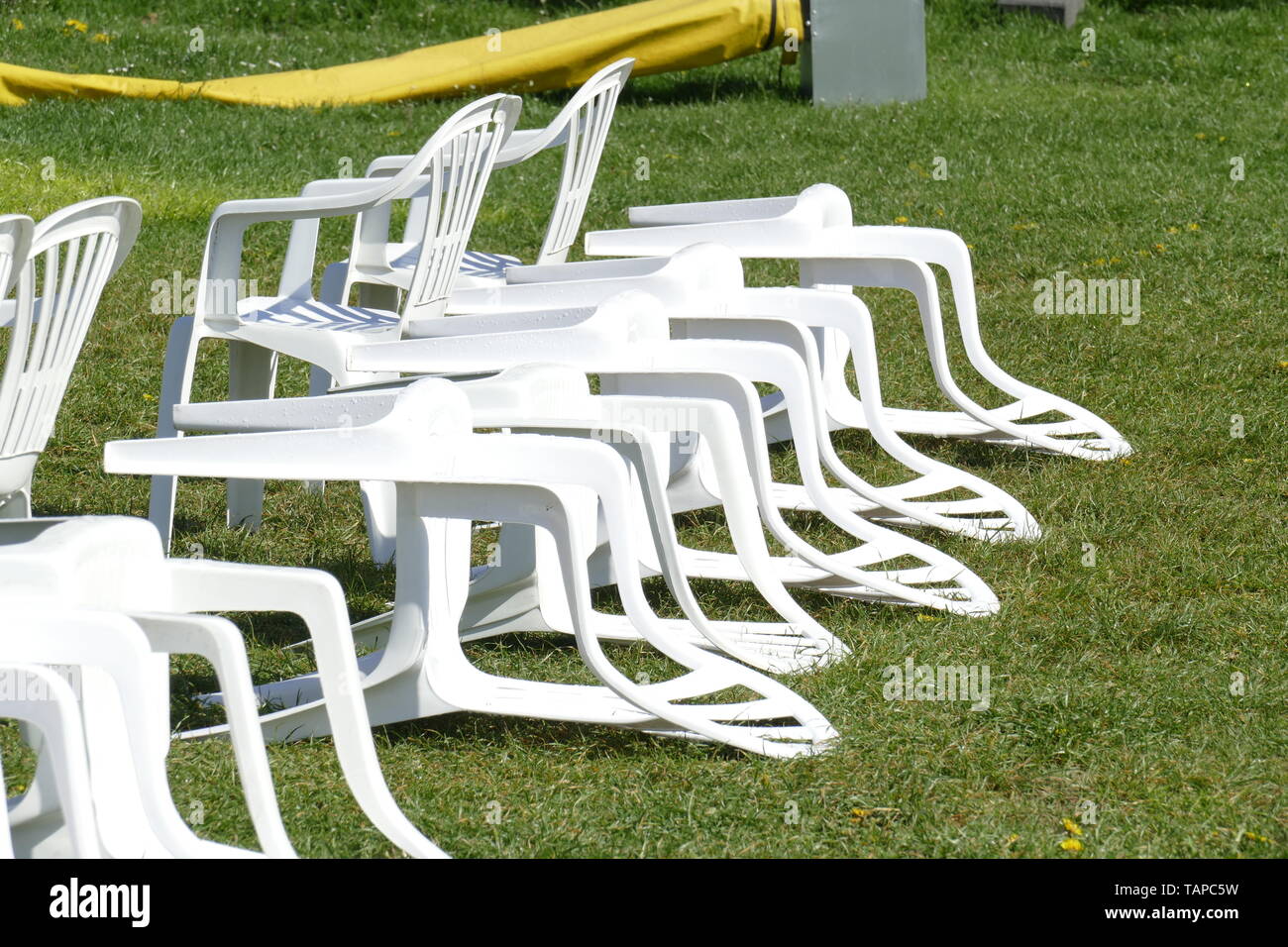 White plastic chairs lying on a meadow, Germany, Europe Stock Photo Alamy