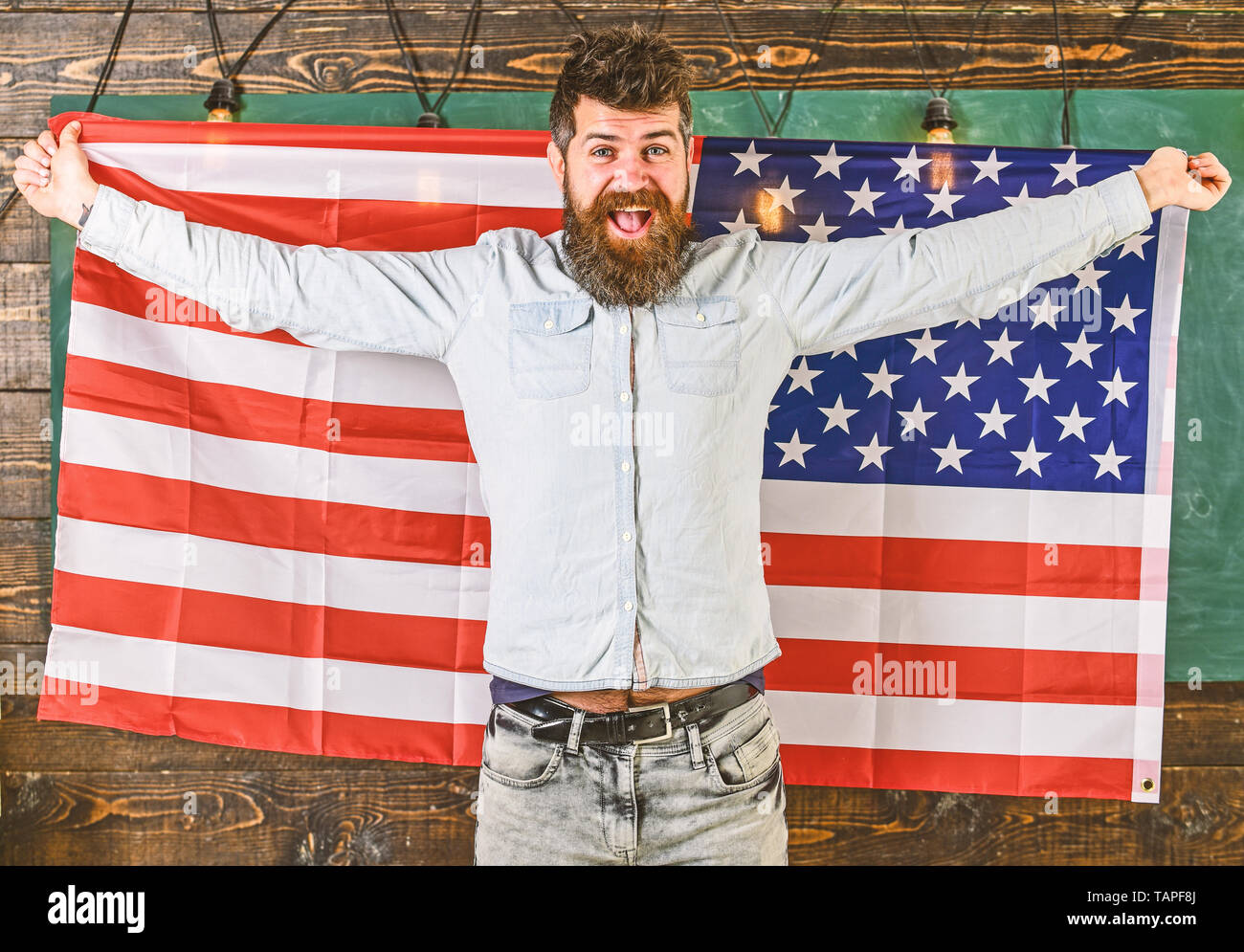 Man with beard and mustache on happy face holds flag of USA wooden background. American teacher holds american flag. American educational system concept. Student exchange program Stock Photo Alamy