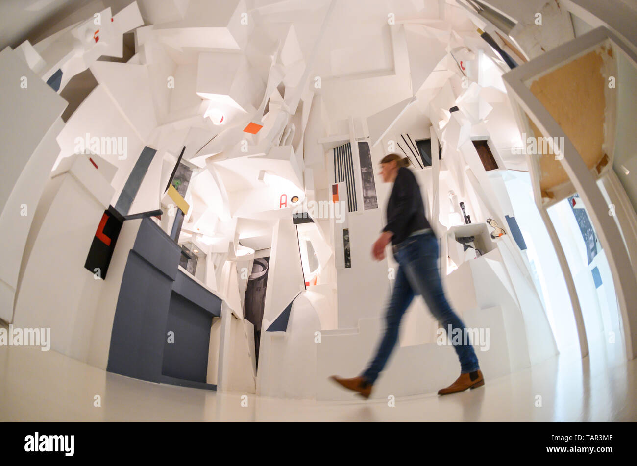 Hanover, Germany. 27th May, 2019. A woman walks in the Sprengel Museum through a reconstruction of the 'Merzbau' (1981-1983) by Kurt Schwitters. In 2019 the Sprengel Museum celebrates the 100th birthday of Merz with an exhibition of over 200 exhibits. Credit: Christophe Gateau/dpa/Alamy Live News Stock Photo