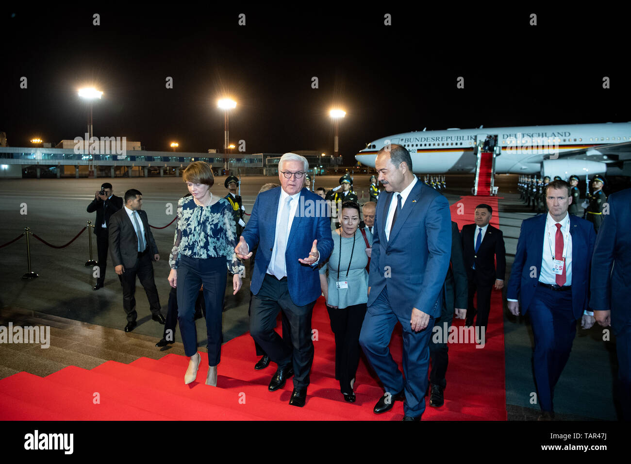 Taschkent, Uzbekistan. 27th May, 2019. President Frank-Walter Steinmeier (in front M) and his wife Elke Büdenbender arrive at Yushny International Tashkent Airport and are welcomed by Abdulla Aripow (r), Prime Minister of Uzbekistan. President Steinmeier and his wife are on a two-day state visit to Uzbekistan. They are accompanied by numerous business representatives and cultural workers. Credit: Bernd von Jutrczenka/dpa/Alamy Live News Stock Photo