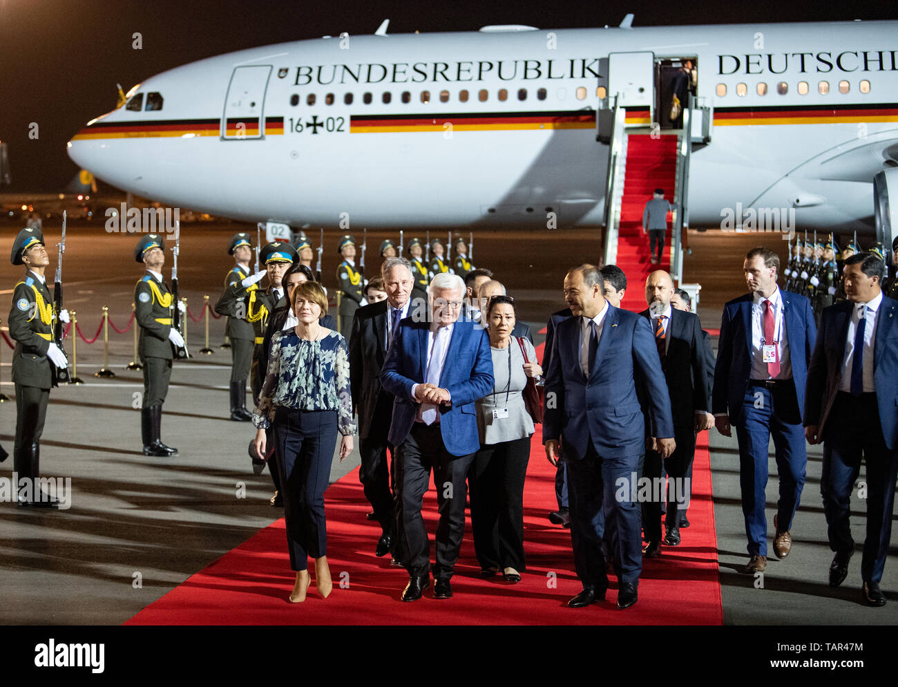 Taschkent, Uzbekistan. 27th May, 2019. President Frank-Walter Steinmeier (in front M) and his wife Elke Büdenbender arrive at Yushny International Tashkent Airport and are welcomed by Abdulla Aripow (r), Prime Minister of Uzbekistan. President Steinmeier and his wife are on a two-day state visit to Uzbekistan. They are accompanied by numerous business representatives and cultural workers. Credit: Bernd von Jutrczenka/dpa/Alamy Live News Stock Photo