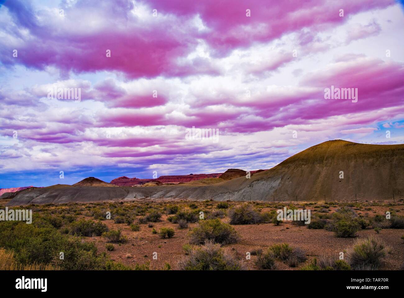 Pink and white cumulus clouds hover over the dry mesas on the Arizona Strip in northern Arizona. Stock Photo