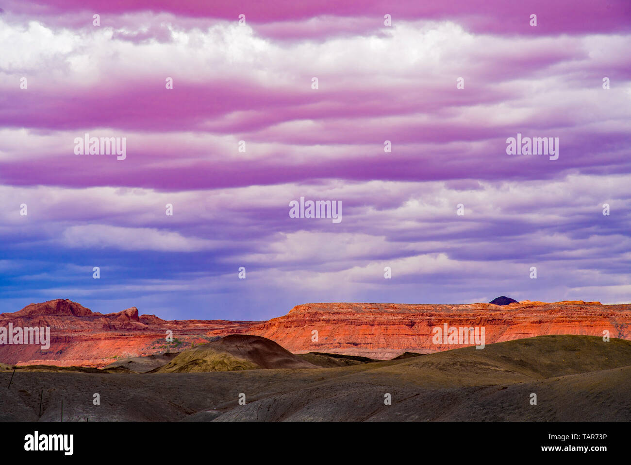 Pink and white cumulus clouds hover over the dry mesas on the Arizona Strip in northern Arizona. Stock Photo