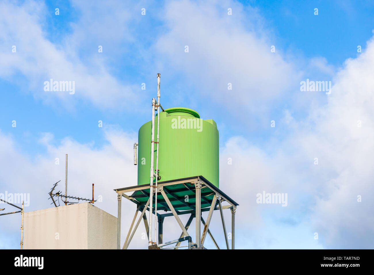Green rooftop water tank against a blue sky with clouds; Naha, Okinawa, Japan Stock Photo