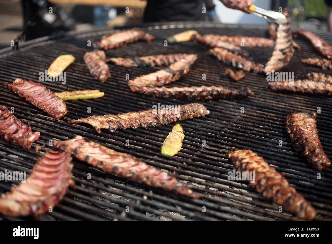 Barbecued pork ribs being cooked on the grill. Street food festival Stock  Photo - Alamy