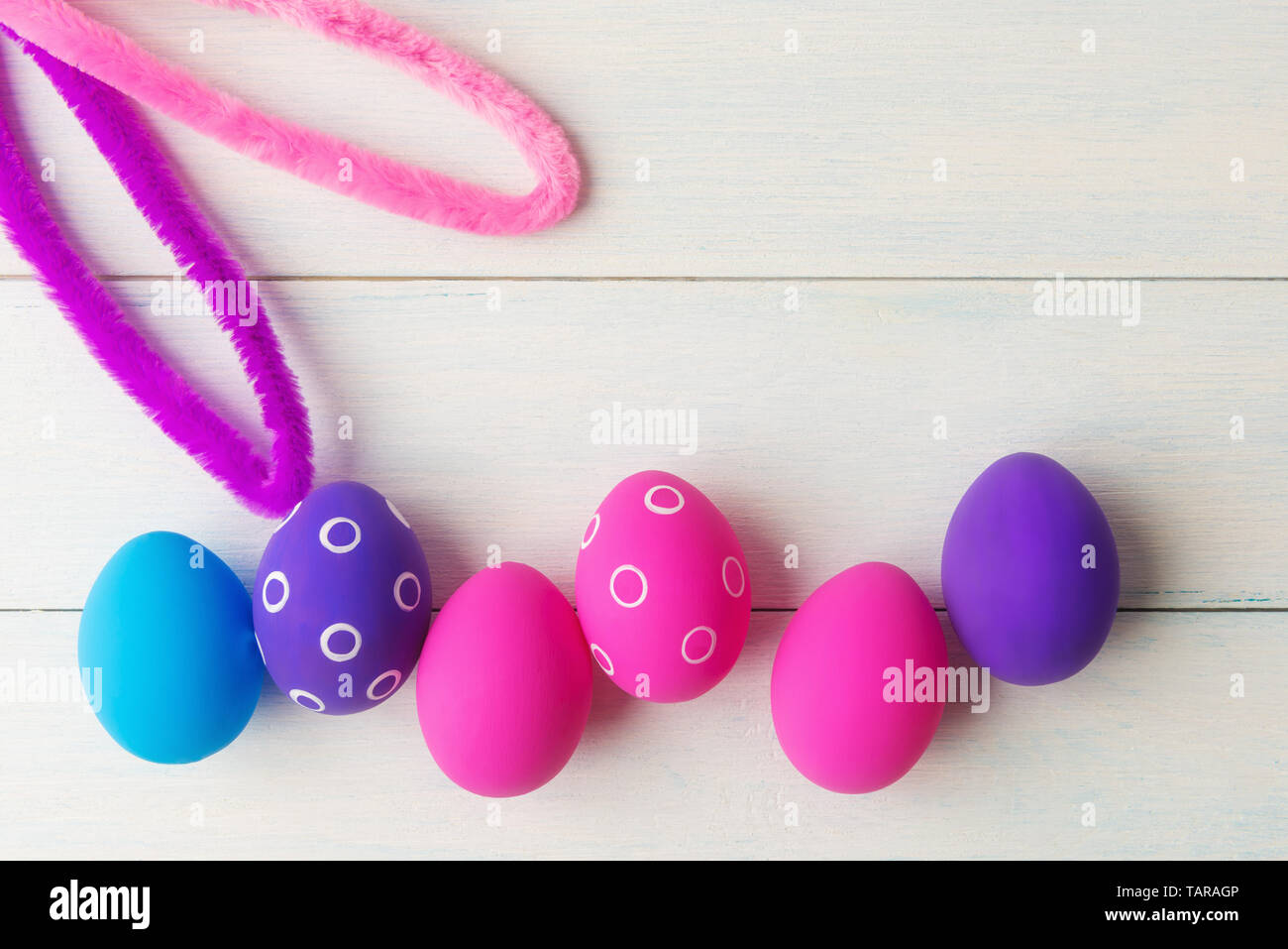 Bunny ears and decorative eggs on wooden background with copy space Stock Photo