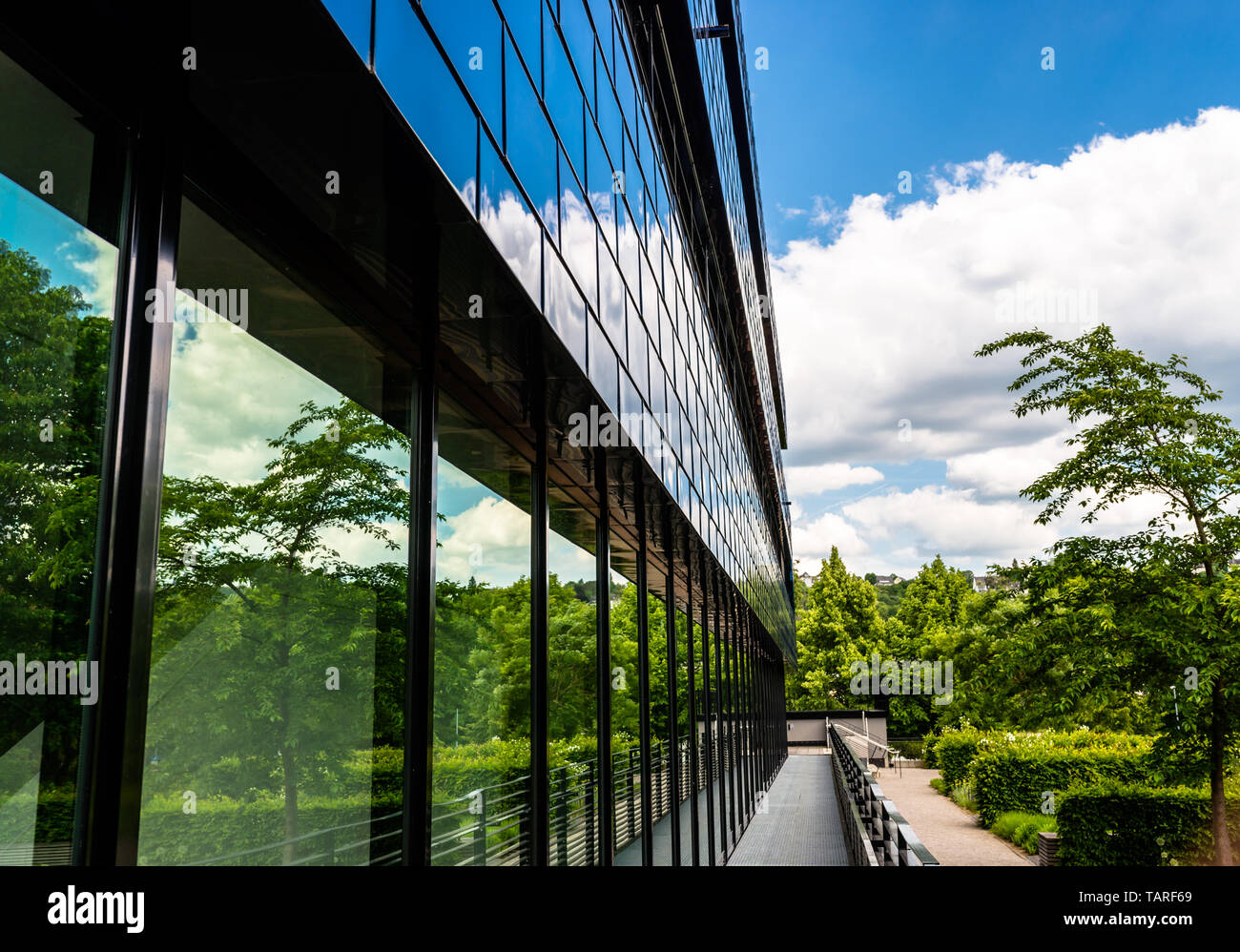 The facade of a modern building made of glass, blue panels in which the sky is reflected. Stock Photo