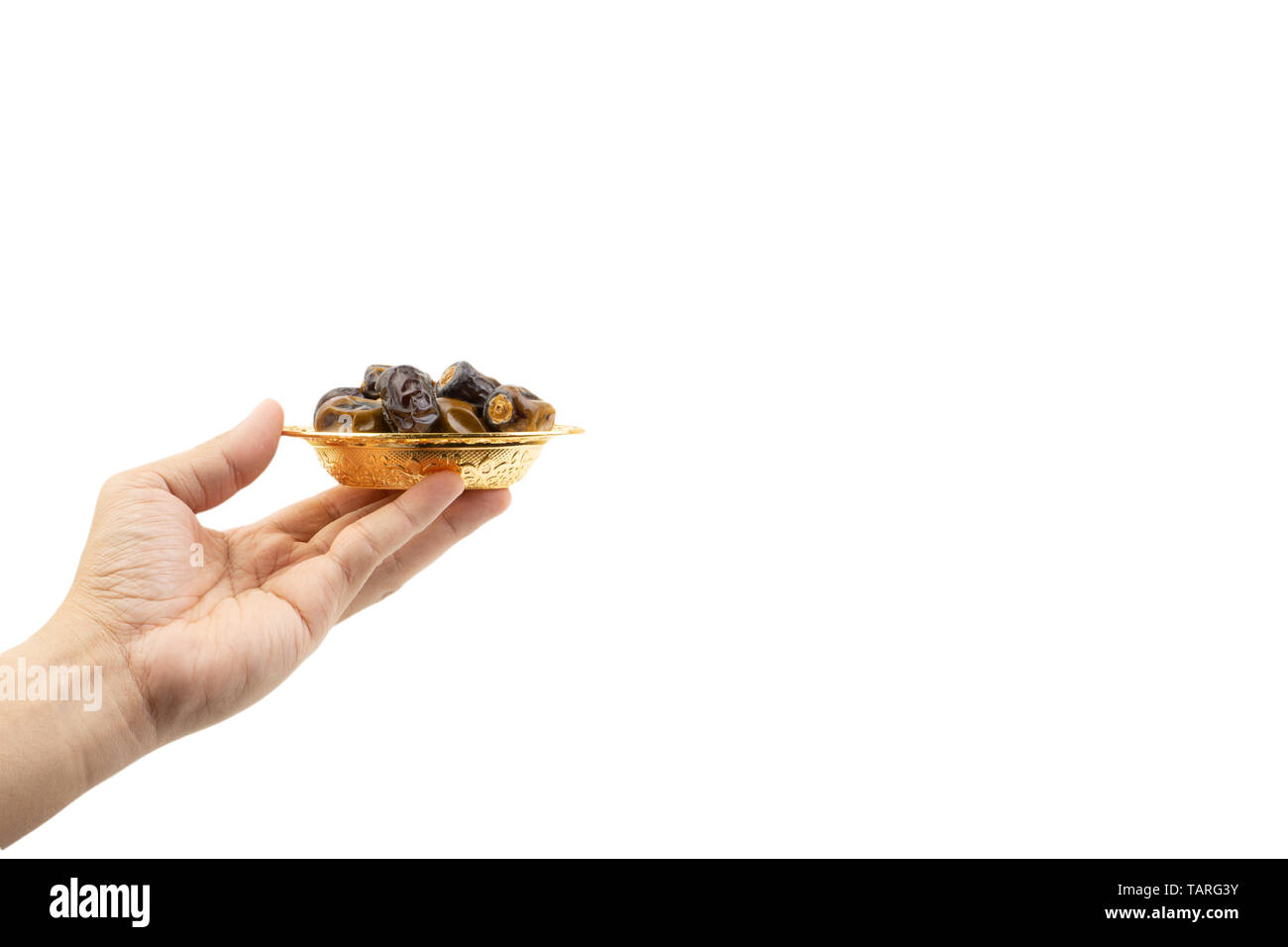 Hand holding dried dates fruits isolate on white. Selective focus Stock Photo
