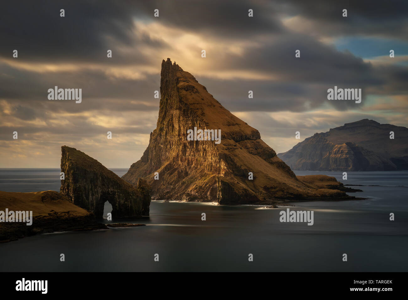 Drangarnir rocky arch on Vagar, Tindholmur and Mykines islands in dusk