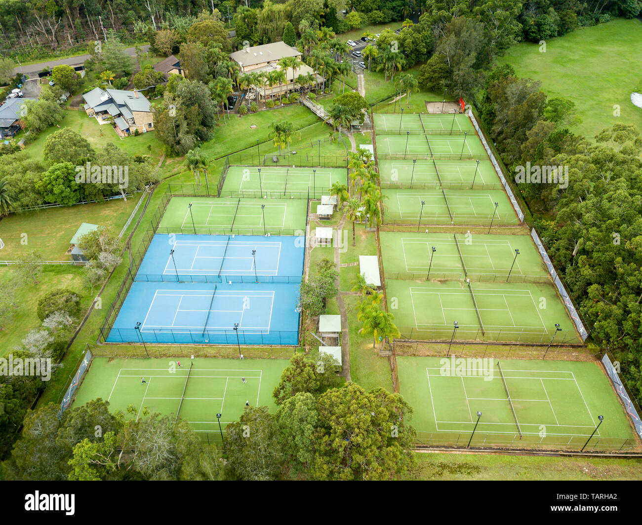 Aerial view of tennis center and facility with blue hard courts and green  artificial grass courts, lush green gardens surrounding Stock Photo - Alamy