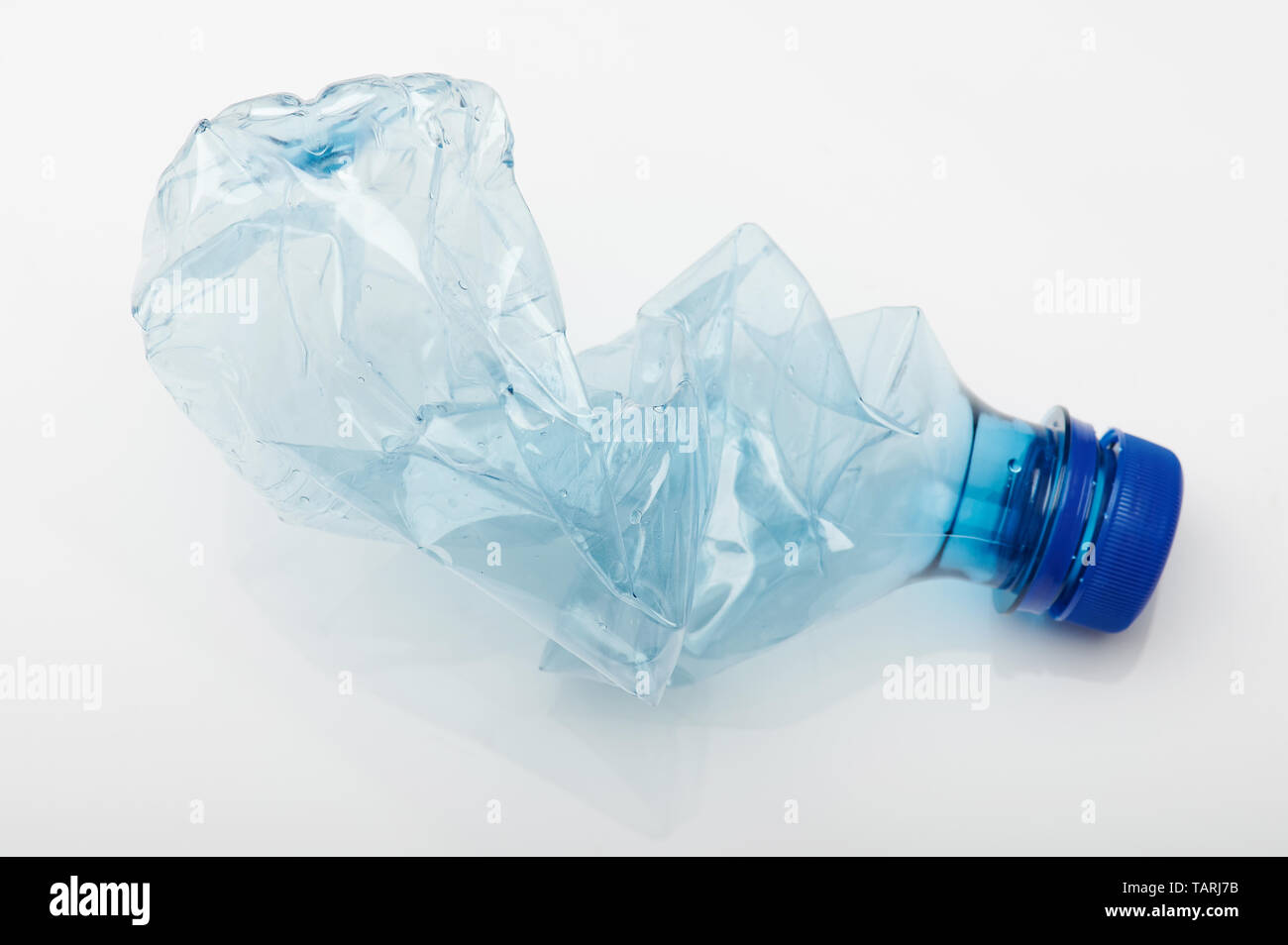 Crashed blue plastic bottle isolated on white studio background Stock Photo