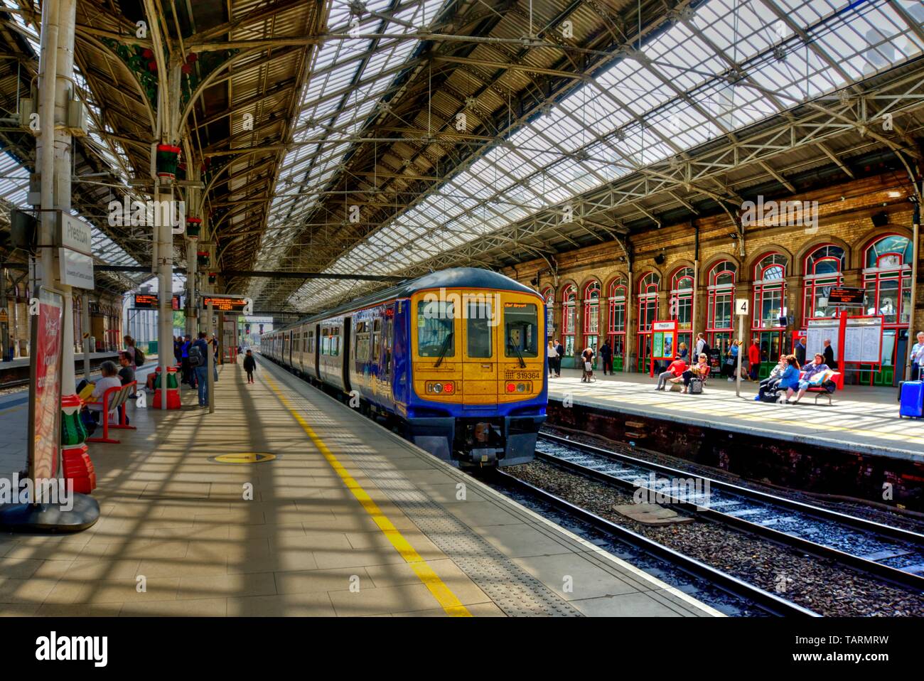 Preston, United Kingdom - May 14, 2019: Preston railway station In north west England with train at platform and passengers some motion blurred on adj Stock Photo