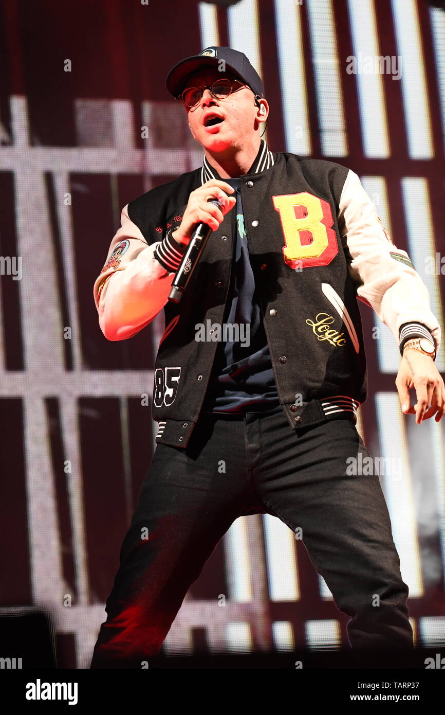 Rapper Logic is shown performing on stage during a live concert