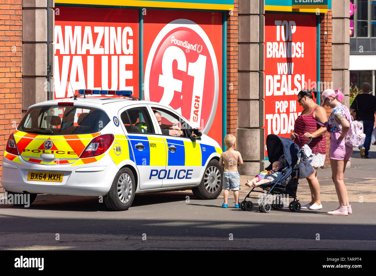 Police having fun chat with family in downtown Walsall, West Midlands, England, United Kingdom Stock Photo