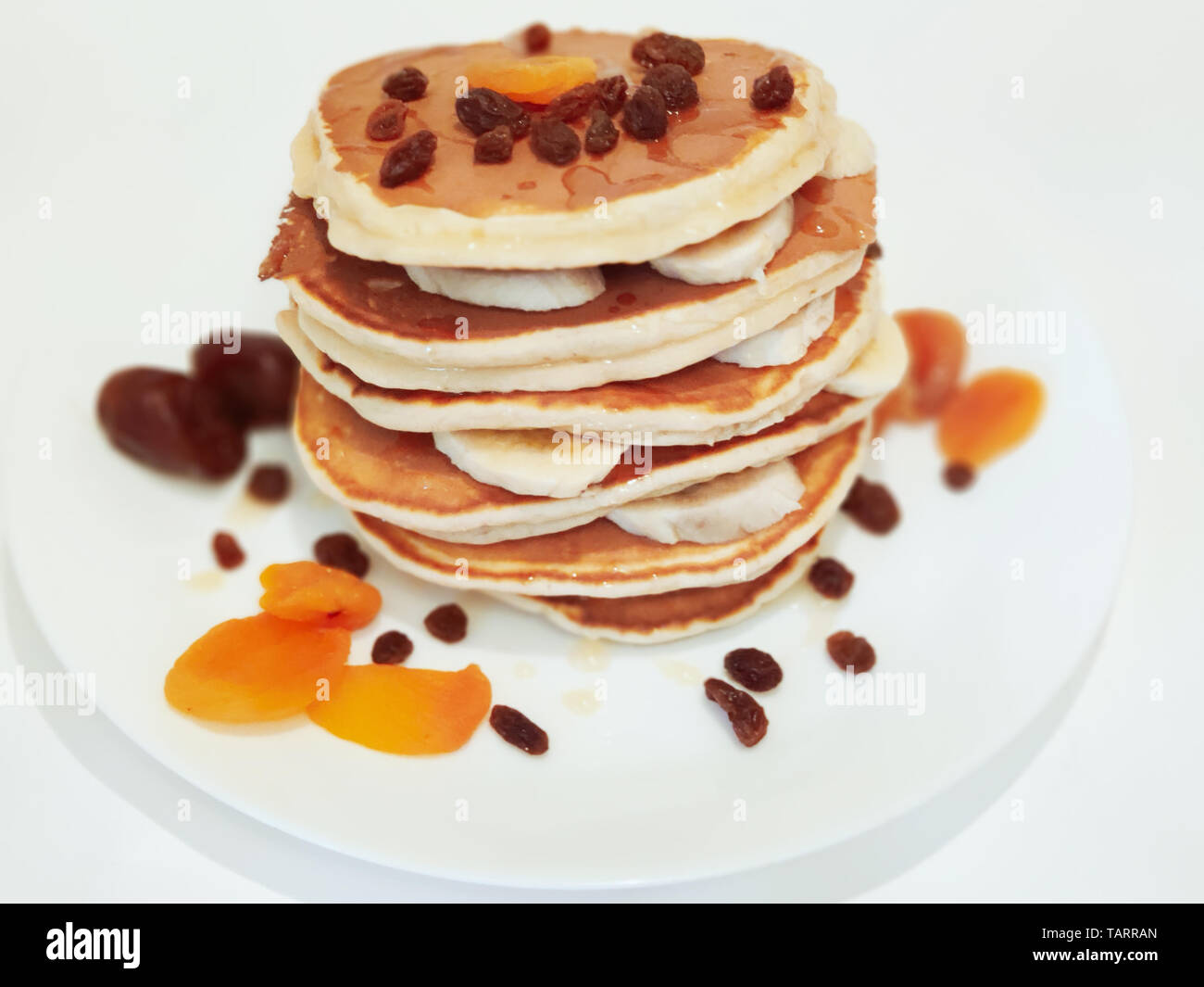 Stack of Pancakes with honey and banana on plate the Table Stock Photo