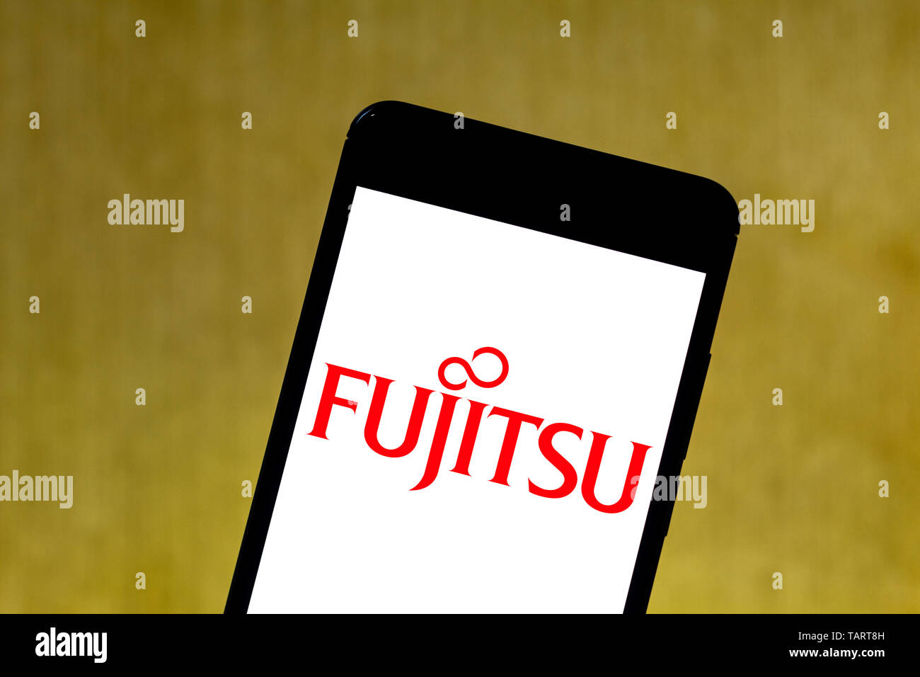 In this photo illustration the Fujitsu logo is seen displayed on a smartphone. Stock Photo