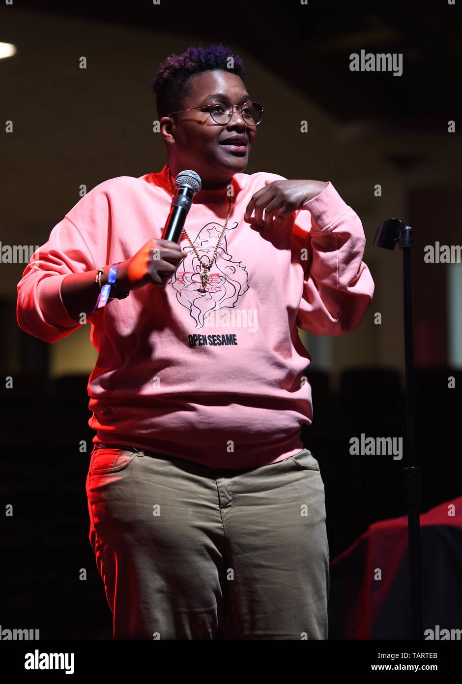 Comedian Sam Jay is shown performing on stage during a "live" stand up concert appearance. Stock Photo