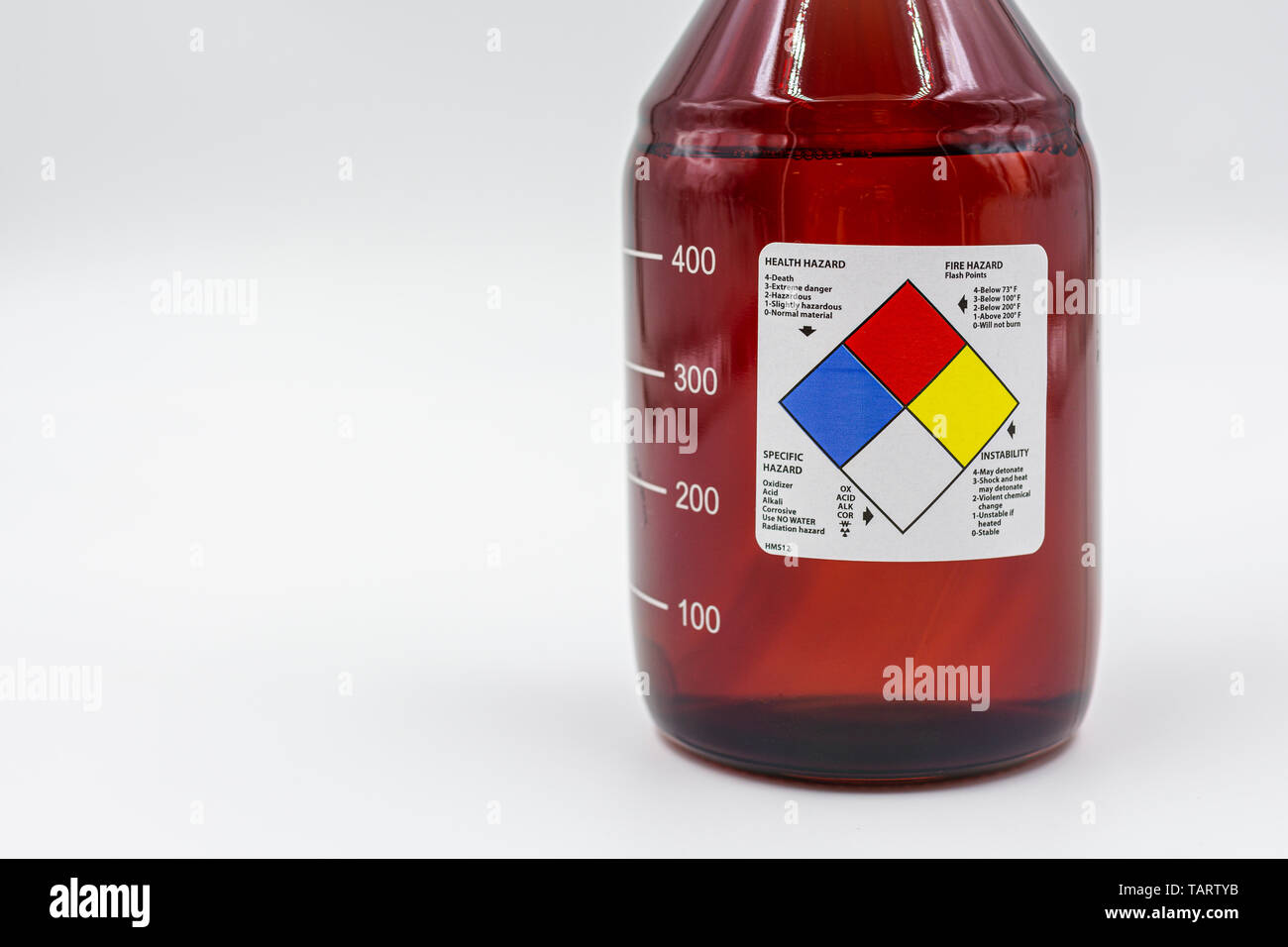 Laboratory amber glass bottle with blank health hazard label on a field of white. Stock Photo