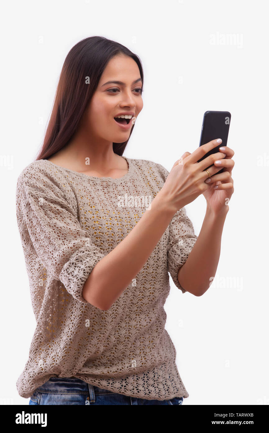 Woman looking at mobile phone with surprise expression Stock Photo