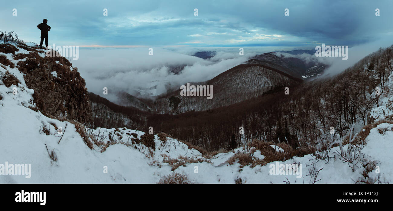 Cloudy mountain at winter with man Stock Photo