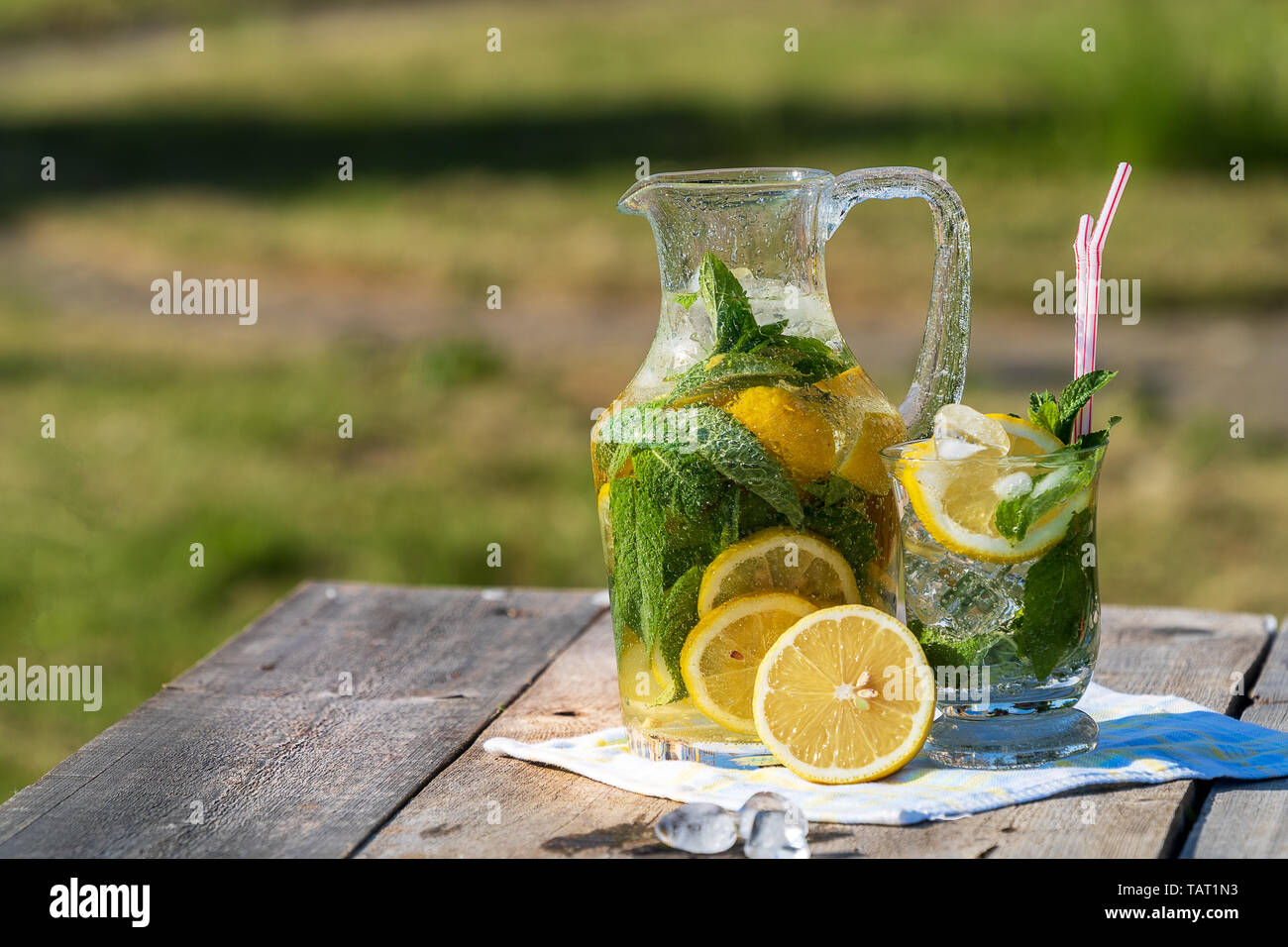 Lemonade Outside Summer concept. Homemade Lemonade with lemon, mint and ice jug and a ...