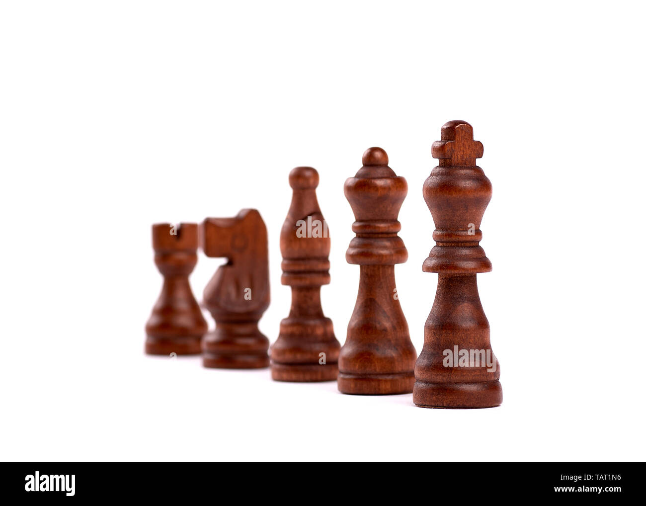 Row of black wooden chess pieces. Team Hierarchy With Defocused Background - Isolated On White Background. Stock Photo