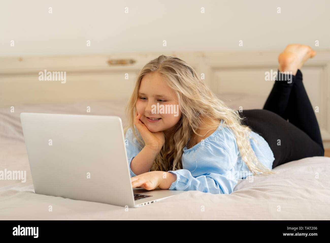 Beautiful cute happy blonde girl playing and surfing the internet on laptop. Child watching cartoon or video on laptop on the bed at home. Digital tec Stock Photo - Alamy Beautiful cute happy blonde girl playing and surfing the internet on laptop. Child watching cartoon or video on laptop on the bed at home. Digital tec Stock Photo - Alamy