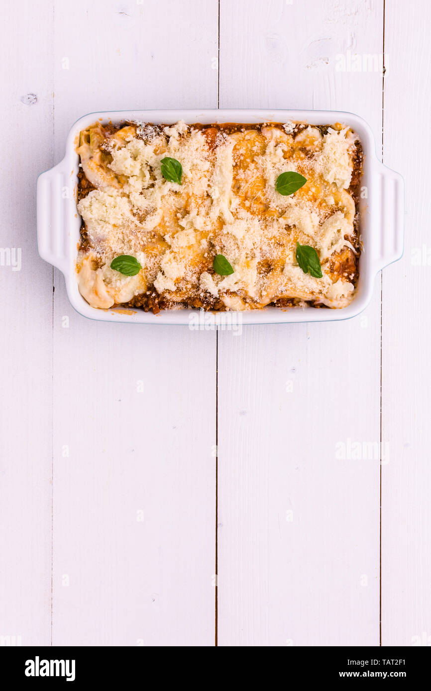 Traditional Italian Lasagna With Minced Beef, Tomato Sauce and Green Basil on White Background Stock Photo