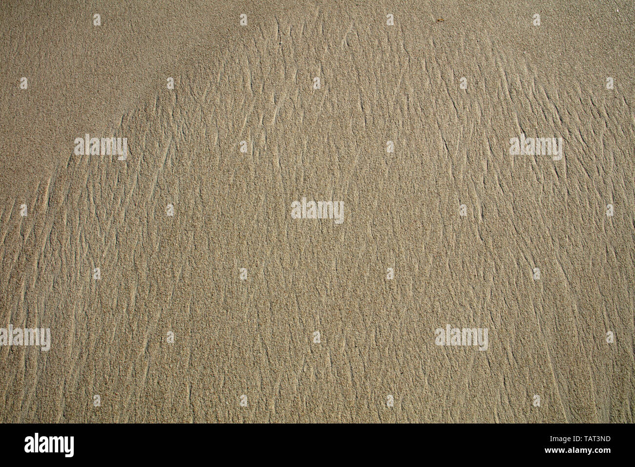 Patterns left by the tidal waves on the beach near the shoreline. Stock Photo