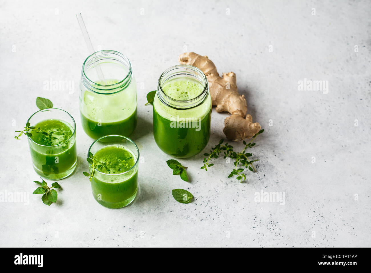 Green detox juice with ginger and mint in glasses and jars. Vegan detox concept. Stock Photo