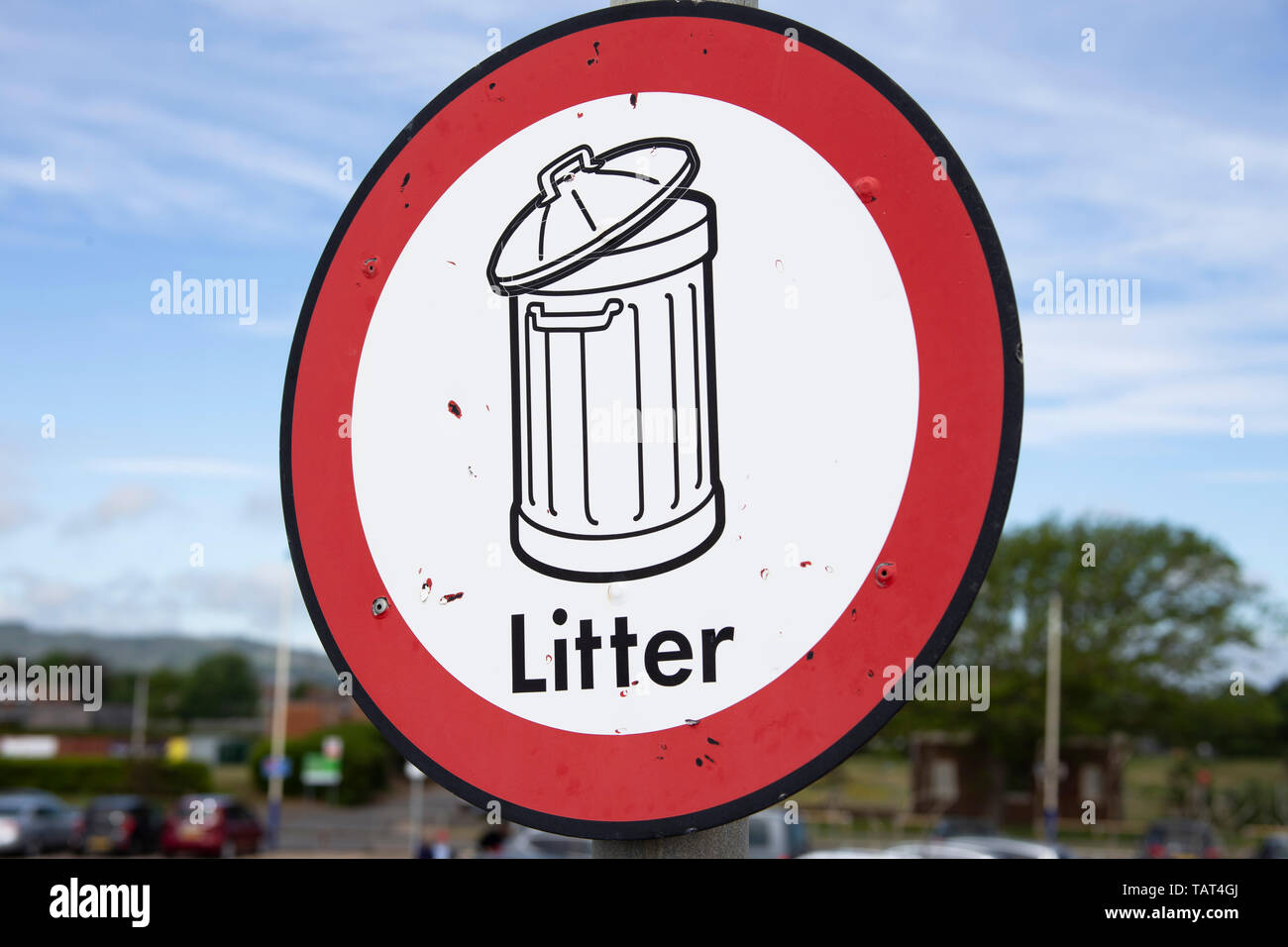 Litter bin sign against blue sky Stock Photo