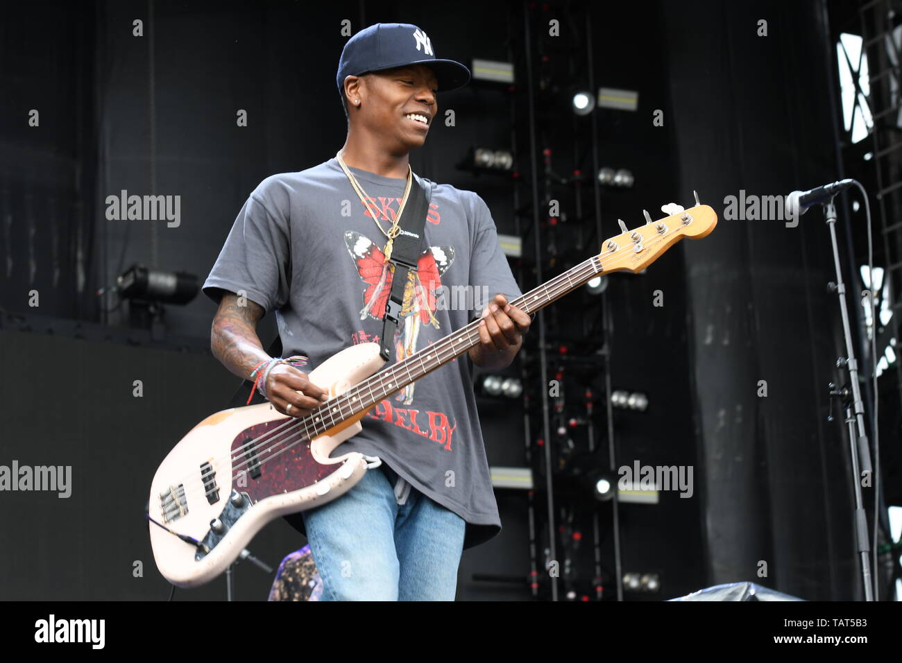 Bass guitarist Franz Lyons is shown performing on stage during a "live" stand up appearance with