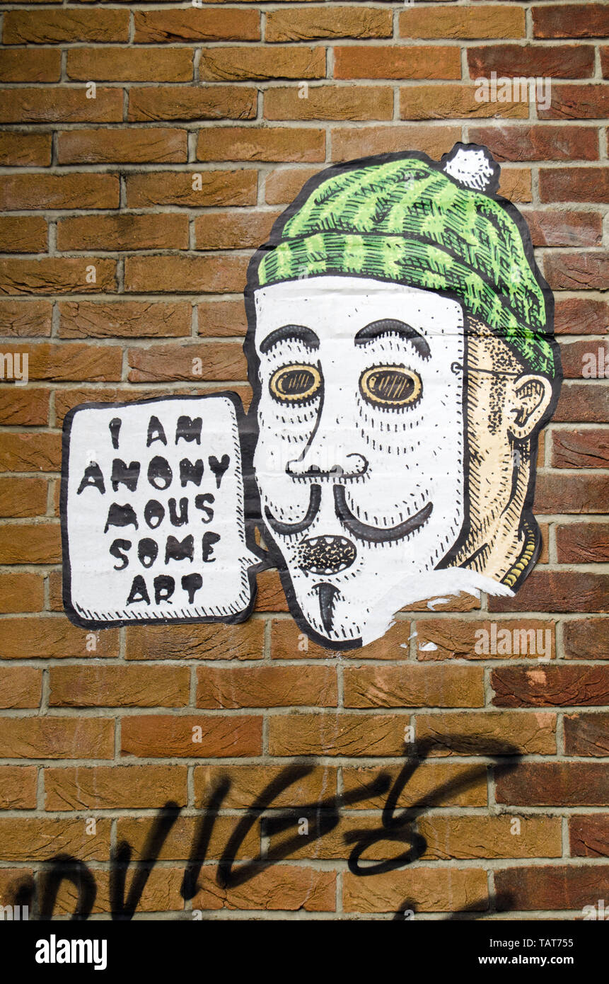 LONDON, UK - MARCH 19, 2016: Arty graffiti using the Anonymous trope on a wall on the trendy Fish Island, Hackney in the East End of London. Stock Photo
