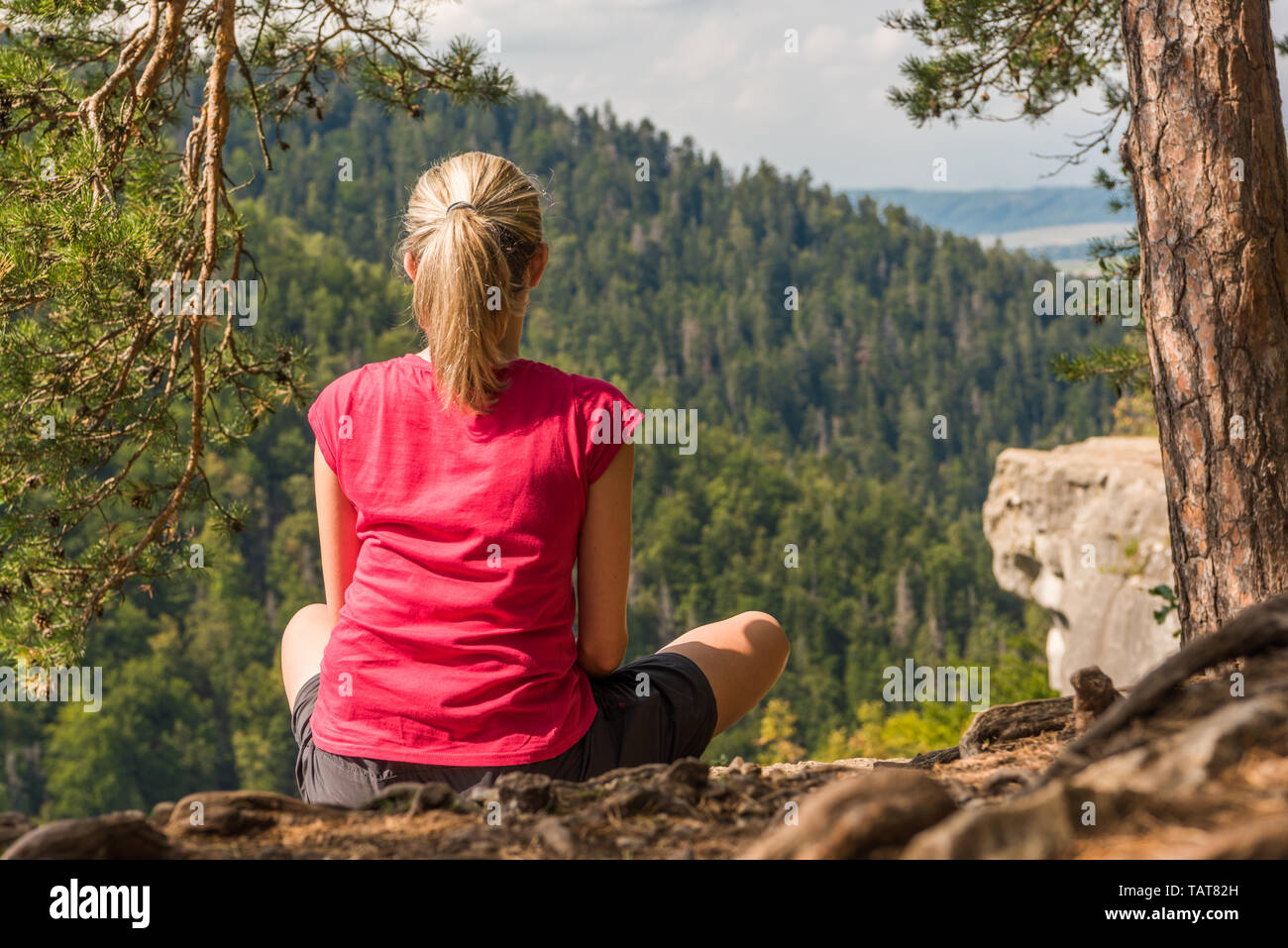Woman sitting in joga posture looking on mountains Stock Photo