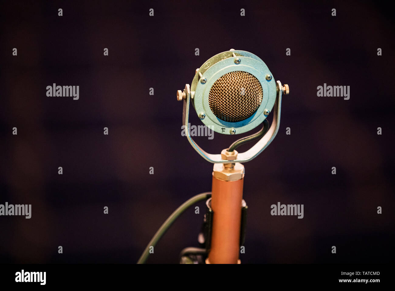 An old type of microphone on the stage against the backdrop of the auditorium. Close-up of retro microphone at concert Stock Photo