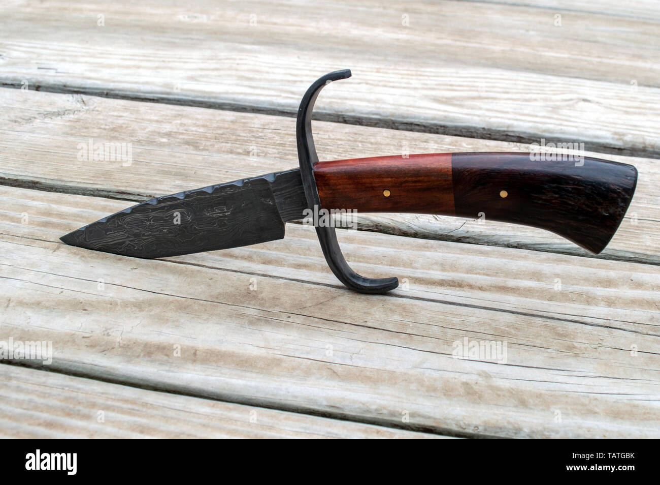 With a bokeh background, this unique bowie knife makes a nice portrait displayed on a wooden deck in Southwest Missouri. Stock Photo