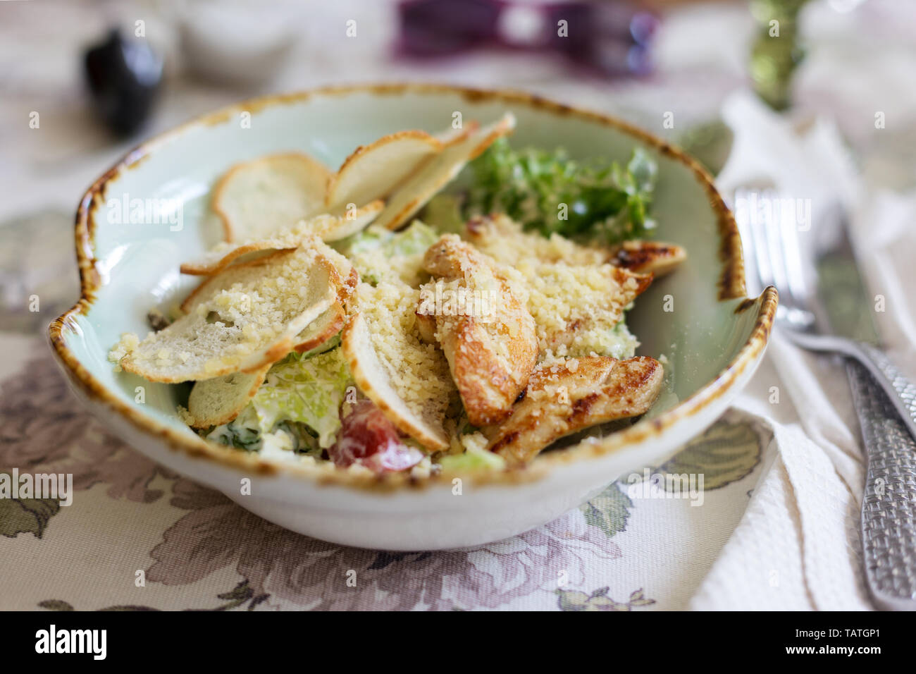 Cesar salad with romano, chicken breasts, croutons and fresh herbs on table. Concept of summer food Stock Photo