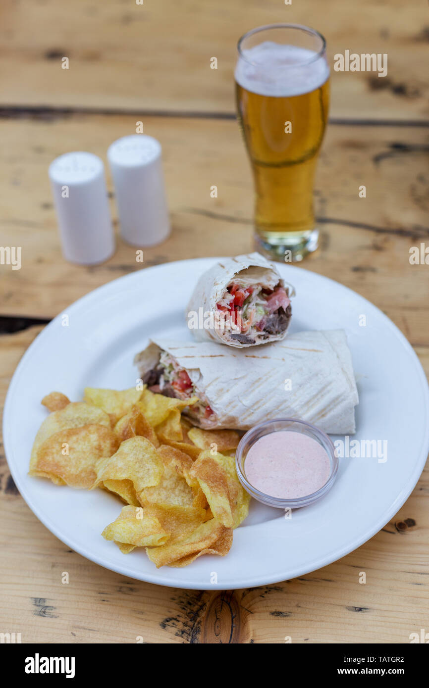 Doner with beef and vegetables with chips and sauce with beer. Concept of snack food Stock Photo