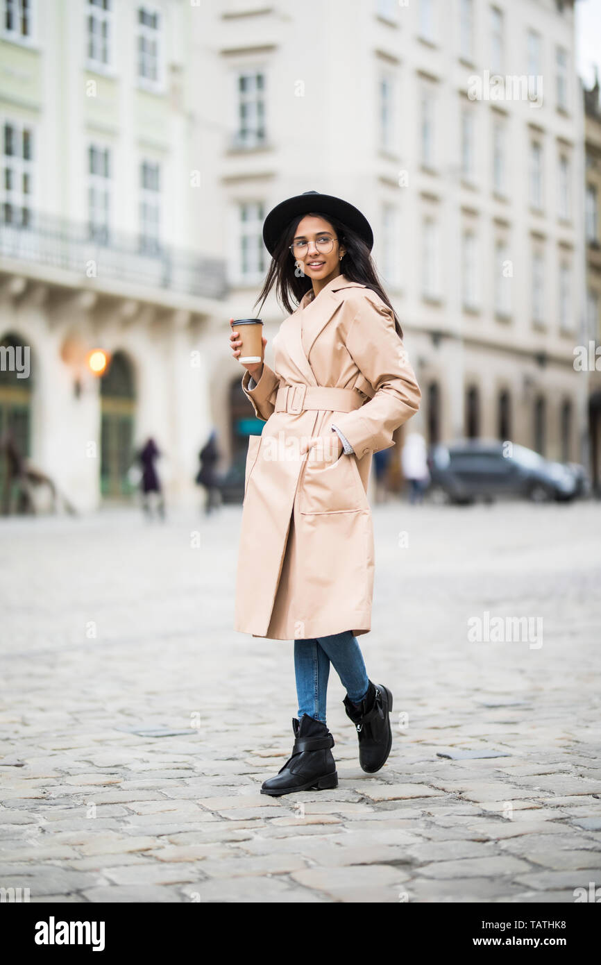 Young woman wearing coat and black hat 