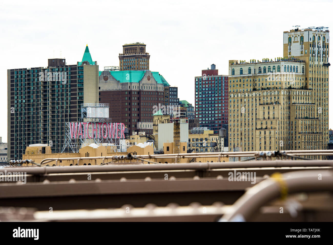 Manhattan skyline with the Watchtower sign seen from the Brooklyn Bridge. Stock Photo