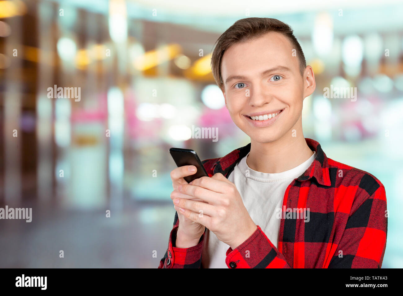 Young man typing text message on his cellphone Stock Photo - Alamy