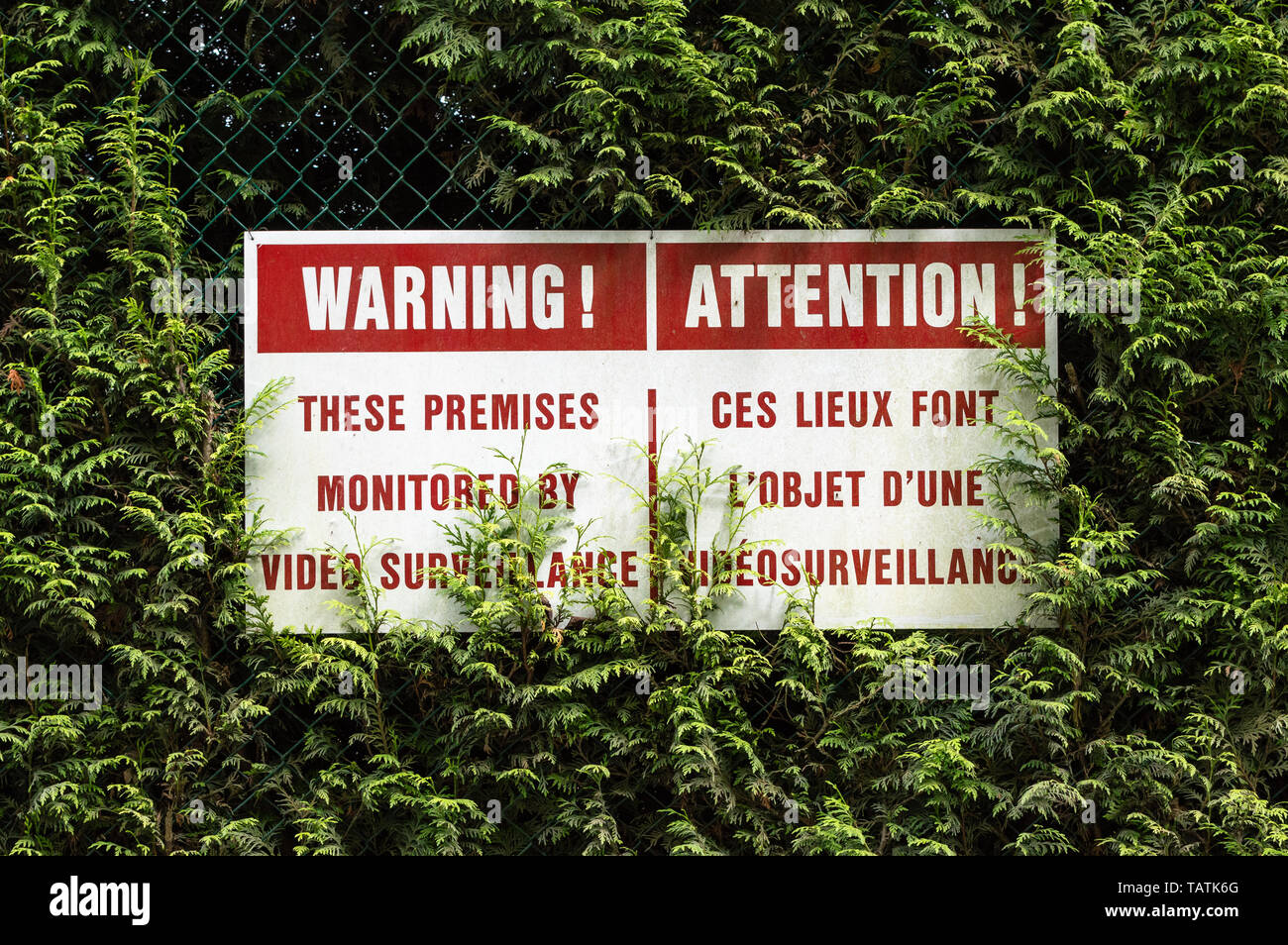 Bilingual English and French language surveillance warning sign with