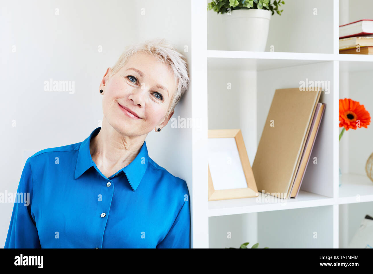 Standing woman in blue shirt hi-res stock photography and images - Alamy