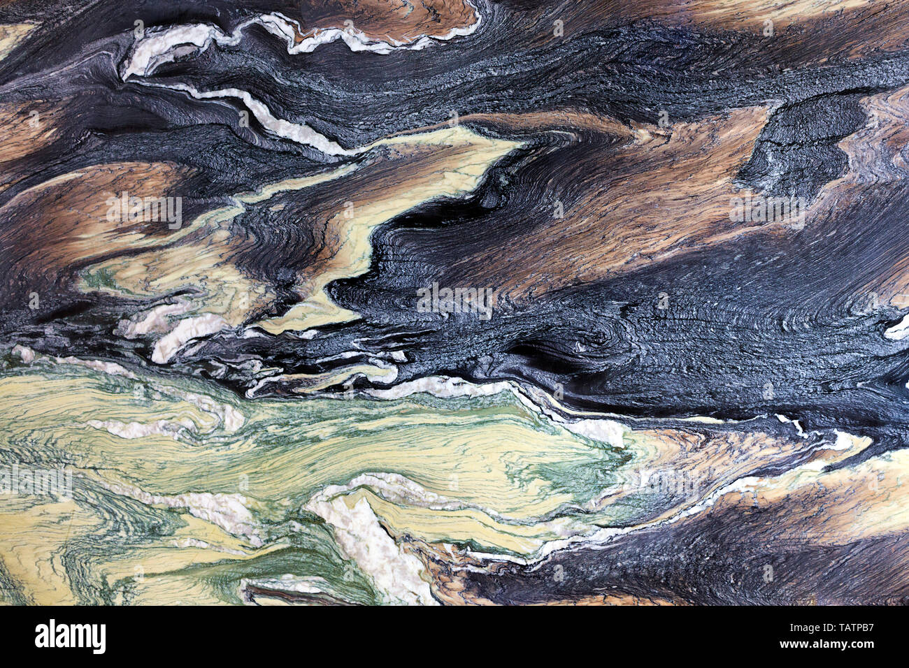 Marble stains that look like frozen lava flows, a chocolate tree, malachite emerald and black and blue shades of coal. Brown, black, green and white m Stock Photo