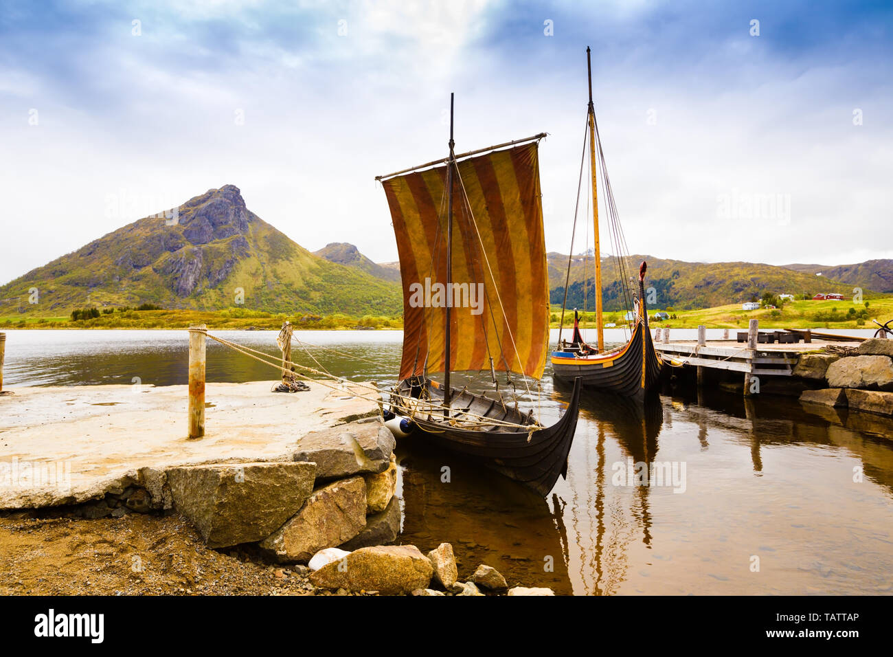 Landscape with viking boats at village small harbor, mountains and fjord in Lofoten islands, Norway. Stock Photo