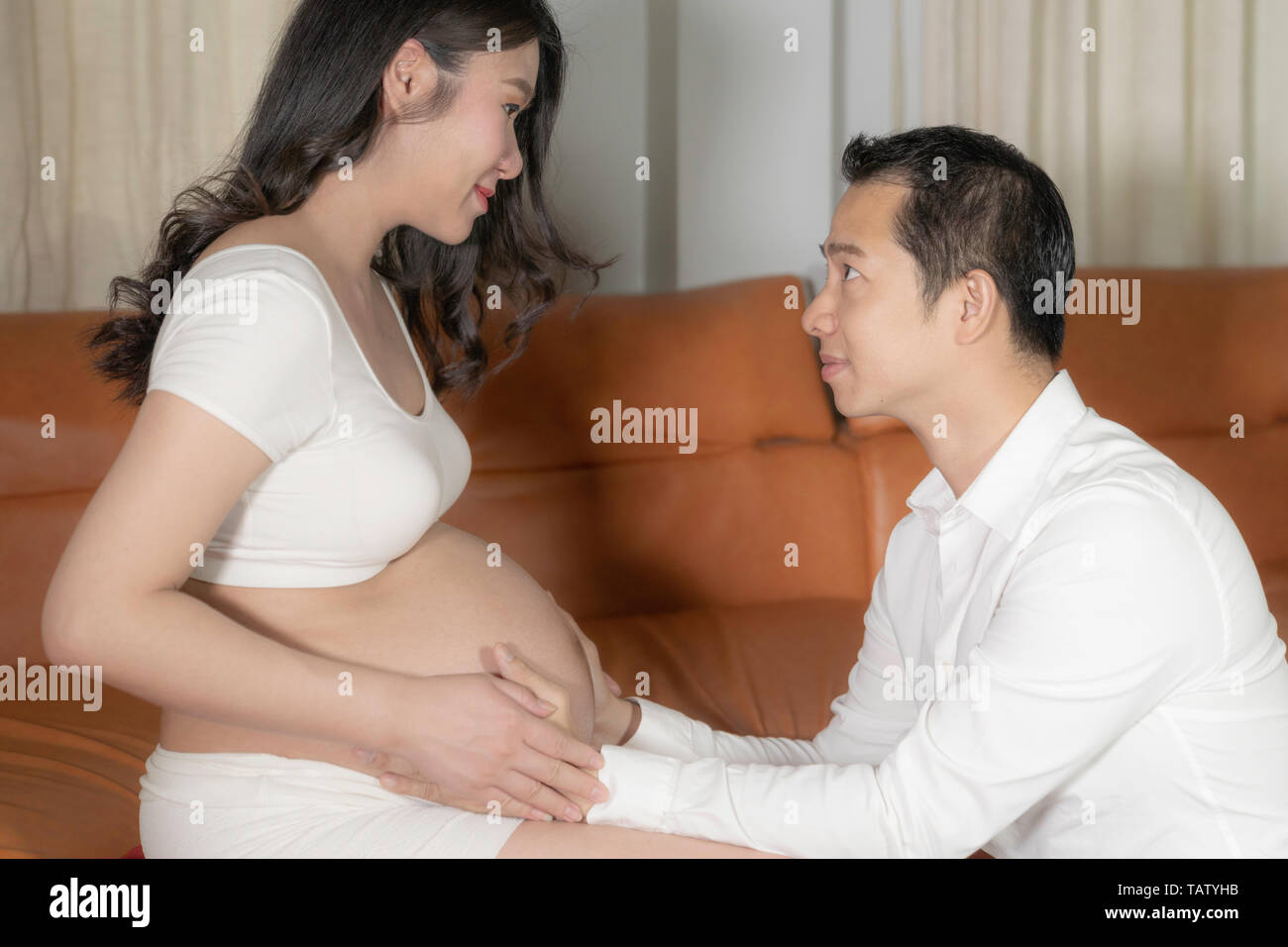 Asian couple pregnant wife and husband happiness in bedroom background Stock Photo image