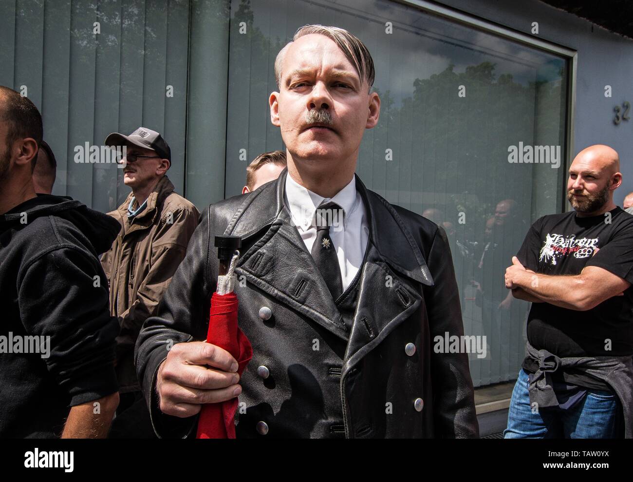 Dortmund, Nordrhein Westfalen, Germany. 25th May, 2019. A neonazi from The Netherlands has fashioned himself into the appearance of Adolph Hitler. On his tie is a pin of the Edelweiss flower, which was used by the SS and is still in use by the Gebirgsjaeger today. Prior to the European Elections, the neonazi party Die Rechte (The Right) organized a rally in the German city of Dortmund to promote their candidate, the incarcerated Holocaust denier Ursula Haverbeck. The demonstration and march were organized by prominent local political figure and neonazi activist Michael Brueck (Michael BrÃ¼ck Stock Photo