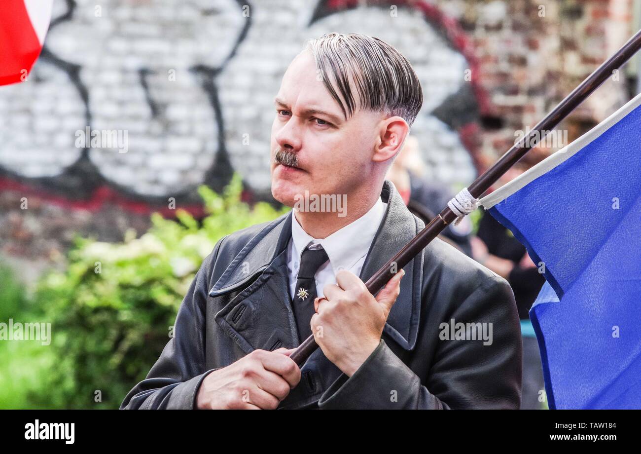 Dortmund, Nordrhein Westfalen, Germany. 25th May, 2019. A neonazi from The Netherlands has fashioned himself into the appearance of Adolph Hitler. On his tie is a pin of the Edelweiss flower, which was used by the SS and is still in use by the Gebirgsjaeger today. Prior to the European Elections, the neonazi party Die Rechte (The Right) organized a rally in the German city of Dortmund to promote their candidate, the incarcerated Holocaust denier Ursula Haverbeck. The demonstration and march were organized by prominent local political figure and neonazi activist Michael Brueck (Michael BrÃ¼ck Stock Photo