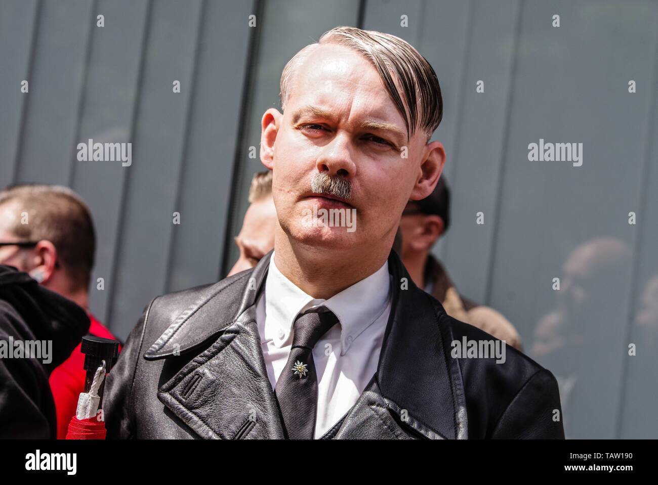 Dortmund, Nordrhein Westfalen, Germany. 25th May, 2019. A neonazi from The Netherlands has fashioned himself into the appearance of Adolph Hitler. On his tie is a pin of the Edelweiss flower, which was used by the SS and is still in use by the Gebirgsjaeger today. Prior to the European Elections, the neonazi party Die Rechte (The Right) organized a rally in the German city of Dortmund to promote their candidate, the incarcerated Holocaust denier Ursula Haverbeck. The demonstration and march were organized by prominent local political figure and neonazi activist Michael Brueck (Michael BrÃ¼ck Stock Photo