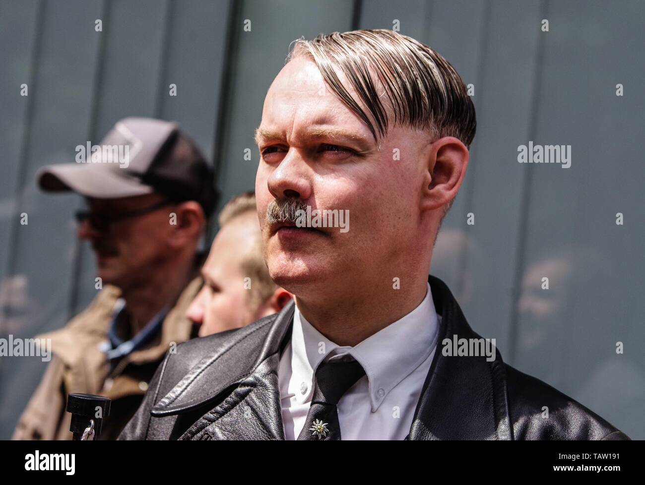 Dortmund, Nordrhein Westfalen, Germany. 25th May, 2019. A neonazi from The Netherlands has fashioned himself into the appearance of Adolph Hitler. On his tie is a pin of the Edelweiss flower, which was used by the SS and is still in use by the Gebirgsjaeger today. Prior to the European Elections, the neonazi party Die Rechte (The Right) organized a rally in the German city of Dortmund to promote their candidate, the incarcerated Holocaust denier Ursula Haverbeck. The demonstration and march were organized by prominent local political figure and neonazi activist Michael Brueck (Michael BrÃ¼ck Stock Photo